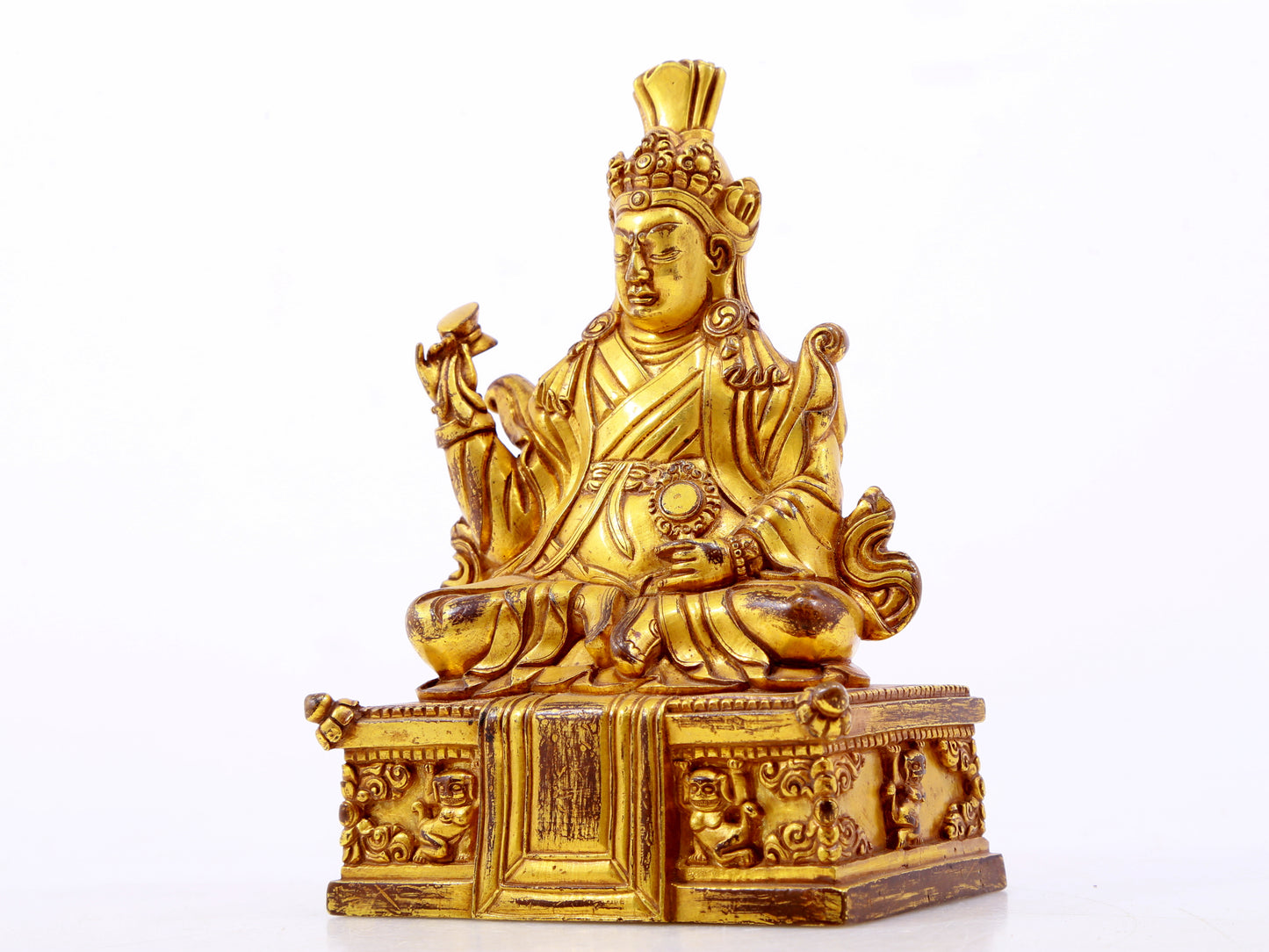 A serene gilt bronze statue of the Guru