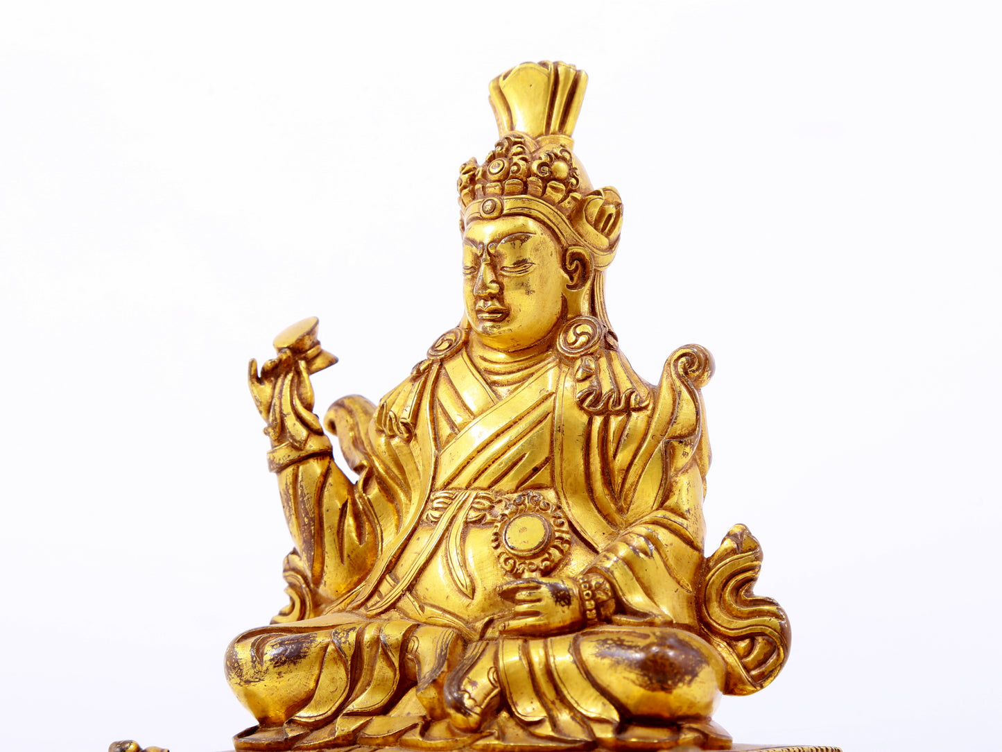 A serene gilt bronze statue of the Guru