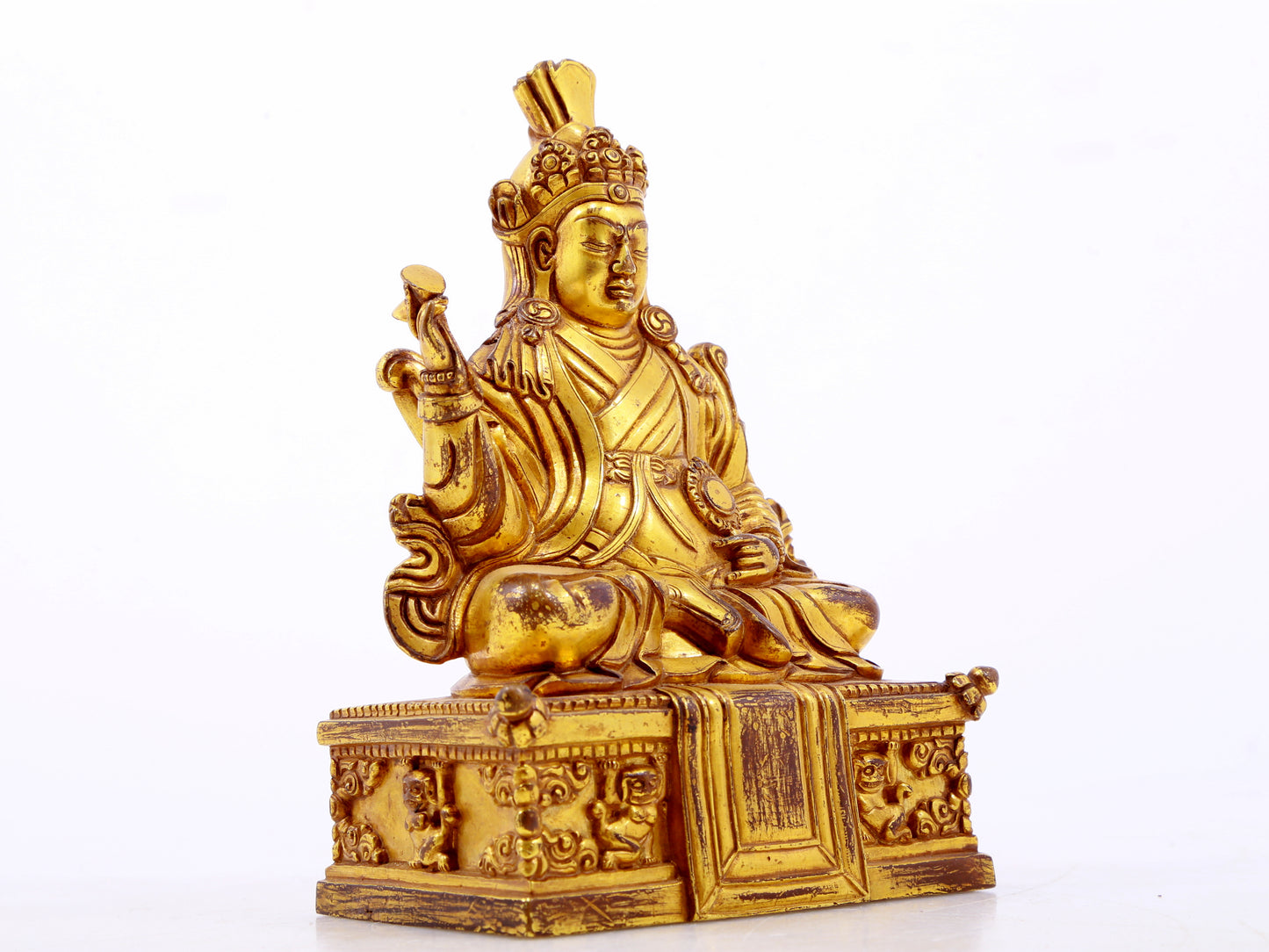 A serene gilt bronze statue of the Guru