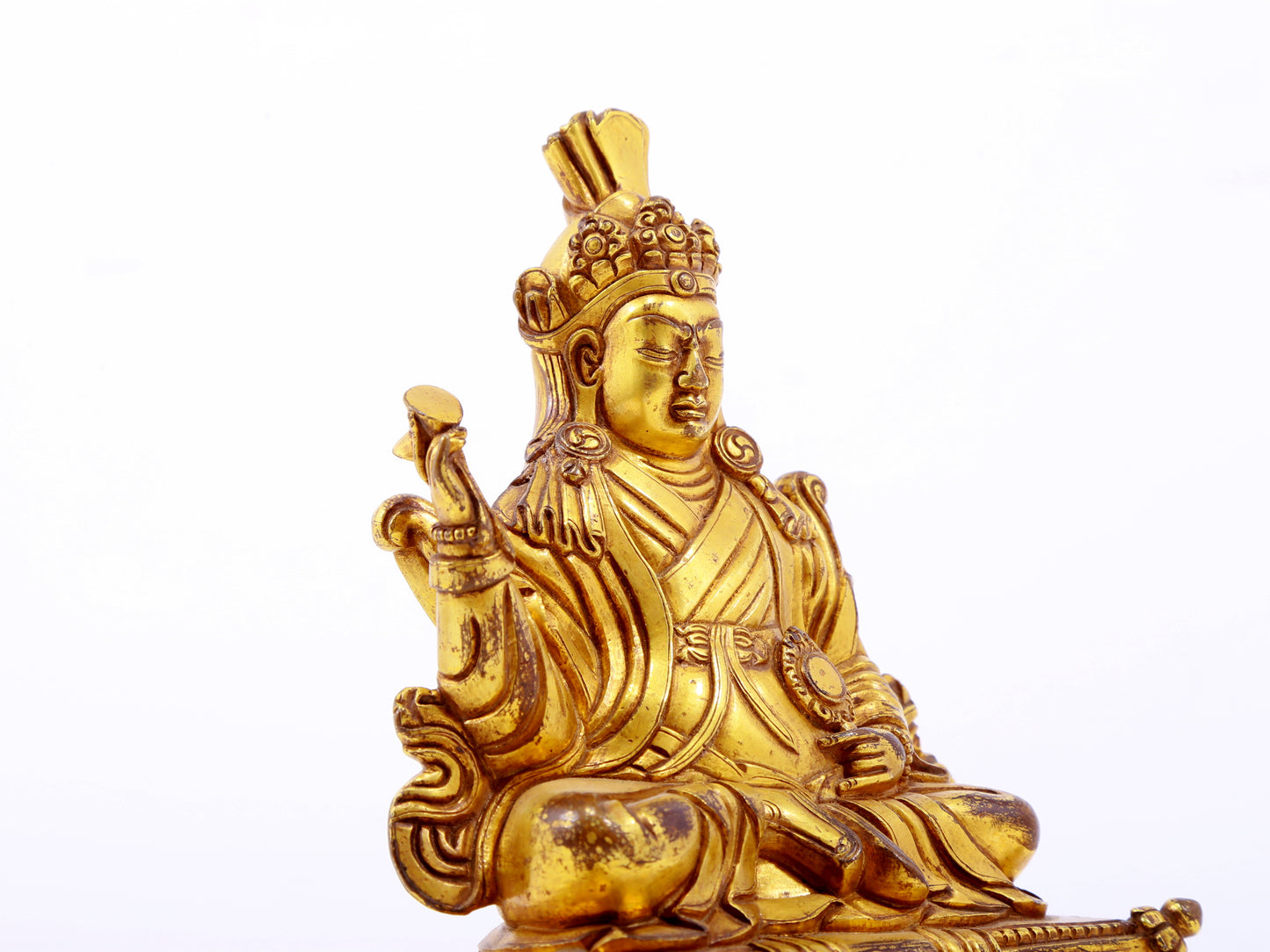 A serene gilt bronze statue of the Guru