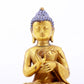 A serene gilt bronze statue of Gautama Buddha