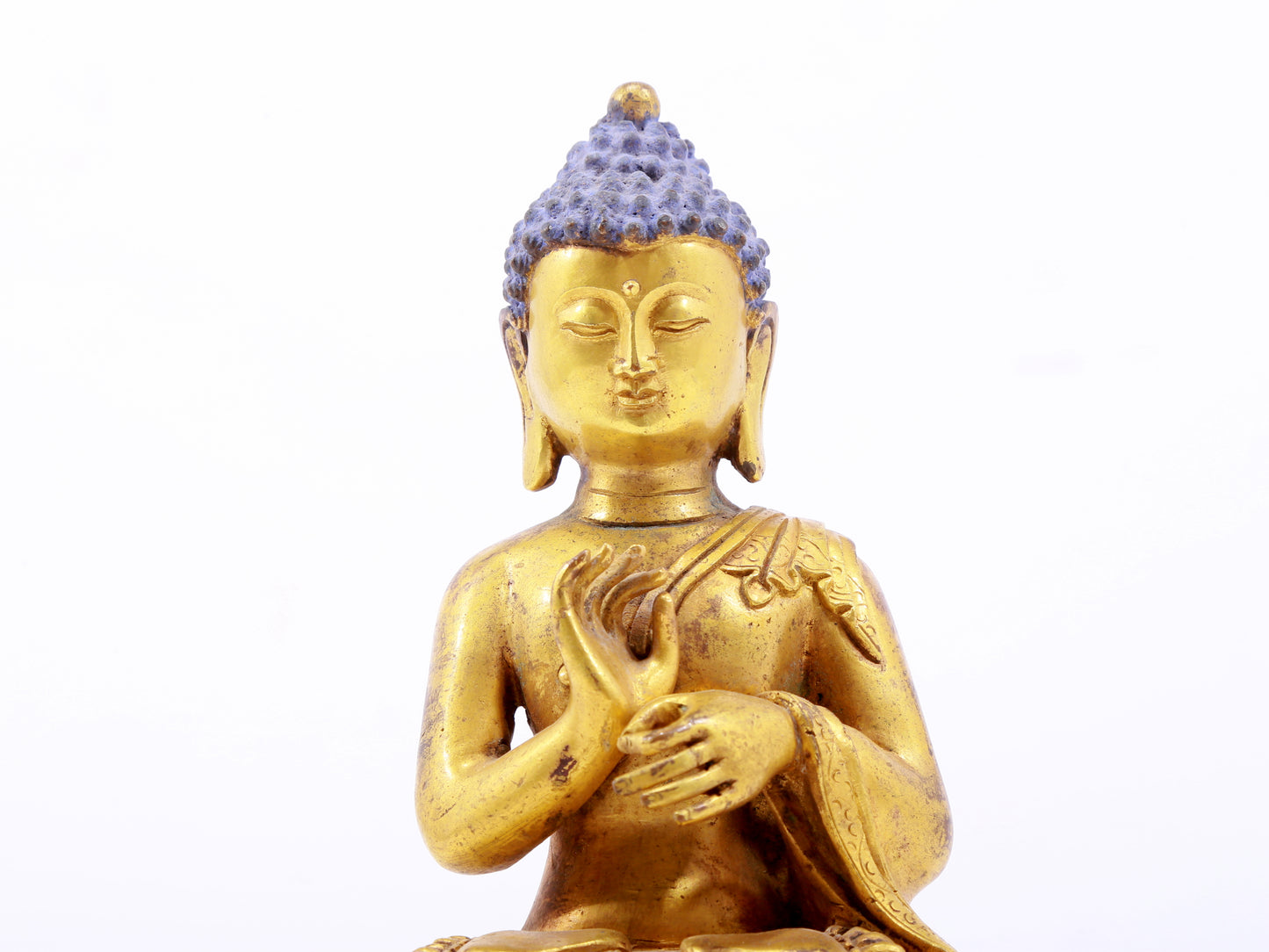 A serene gilt bronze statue of Gautama Buddha