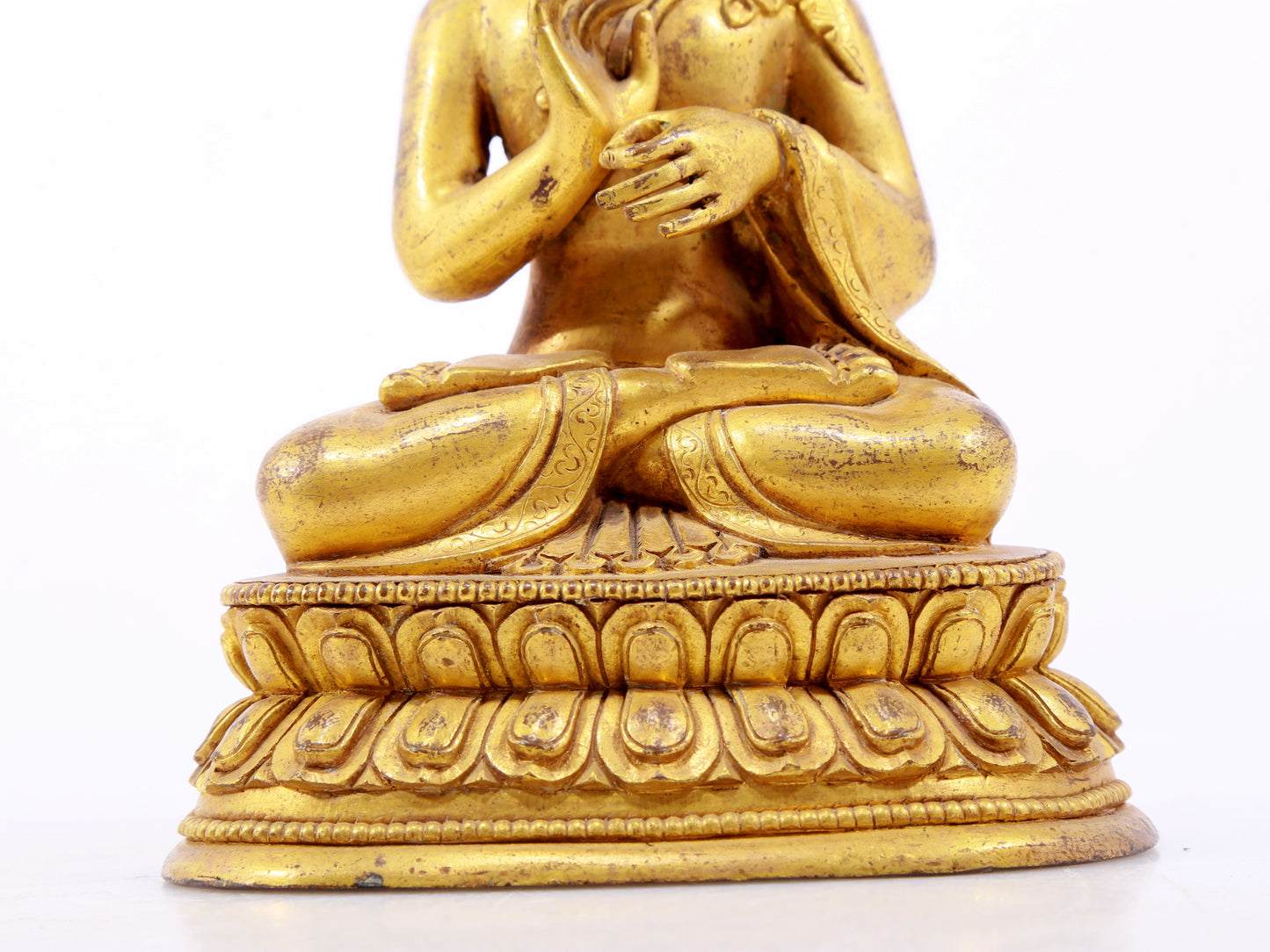 A serene gilt bronze statue of Gautama Buddha