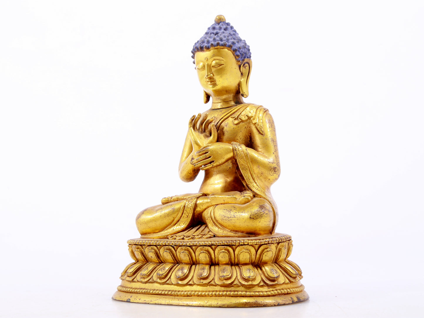 A serene gilt bronze statue of Gautama Buddha