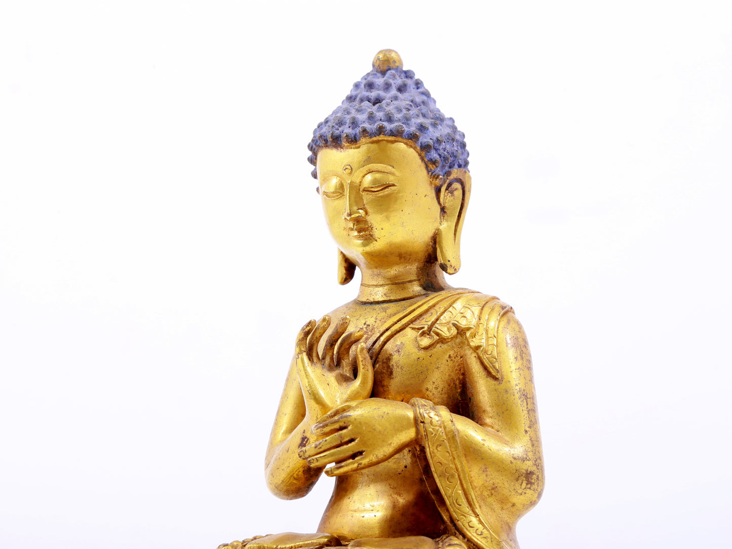 A serene gilt bronze statue of Gautama Buddha