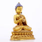 A serene gilt bronze statue of Gautama Buddha