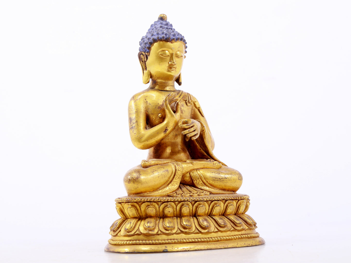 A serene gilt bronze statue of Gautama Buddha