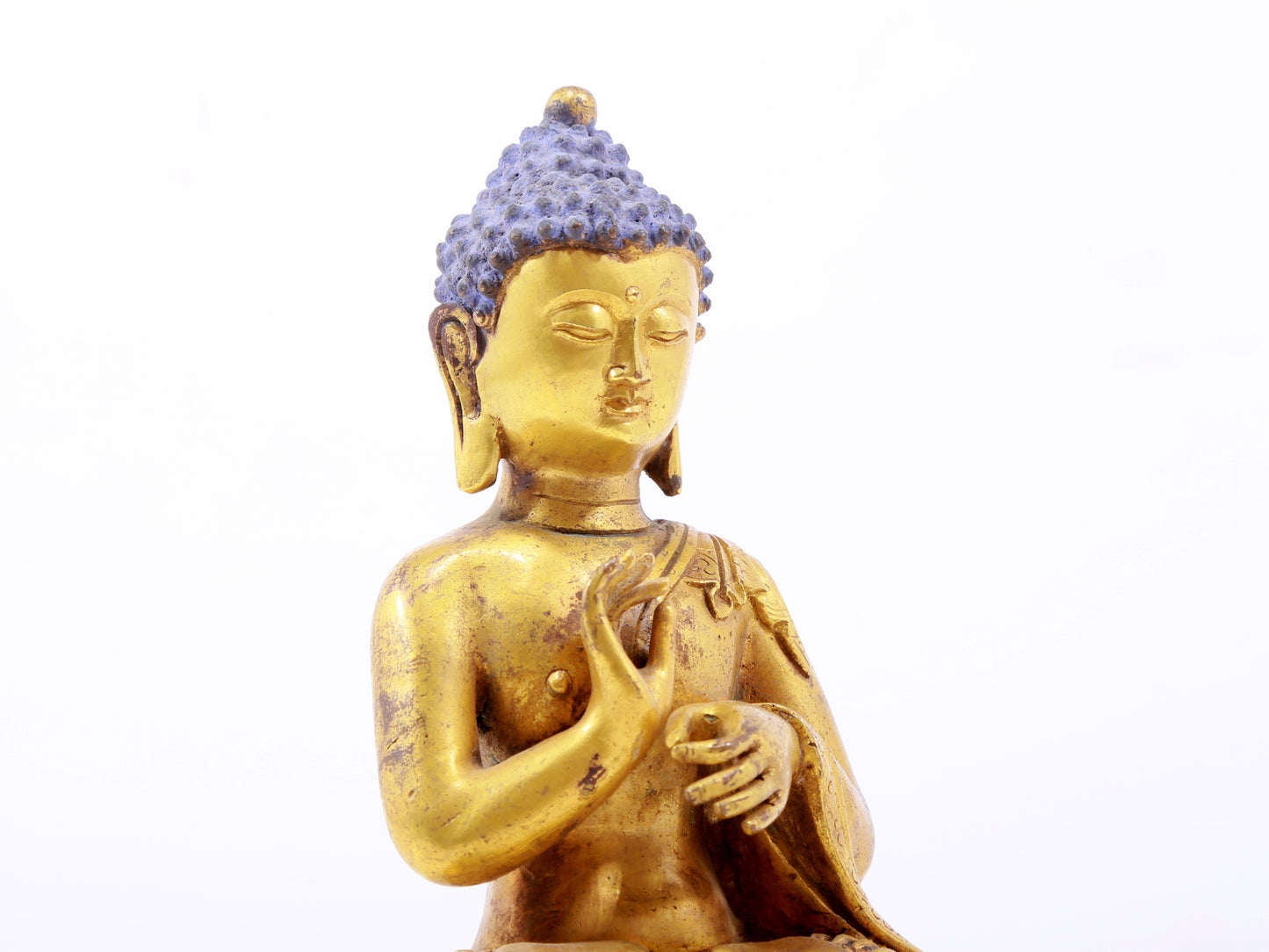 A serene gilt bronze statue of Gautama Buddha