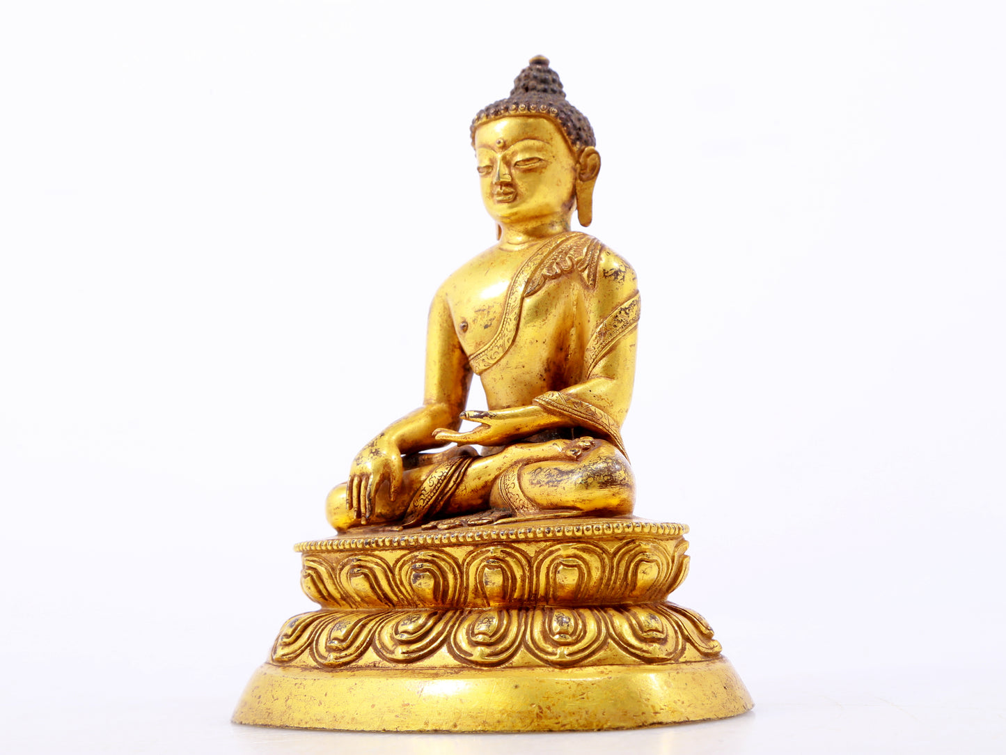 A serene gilt bronze statue of Gautama Buddha