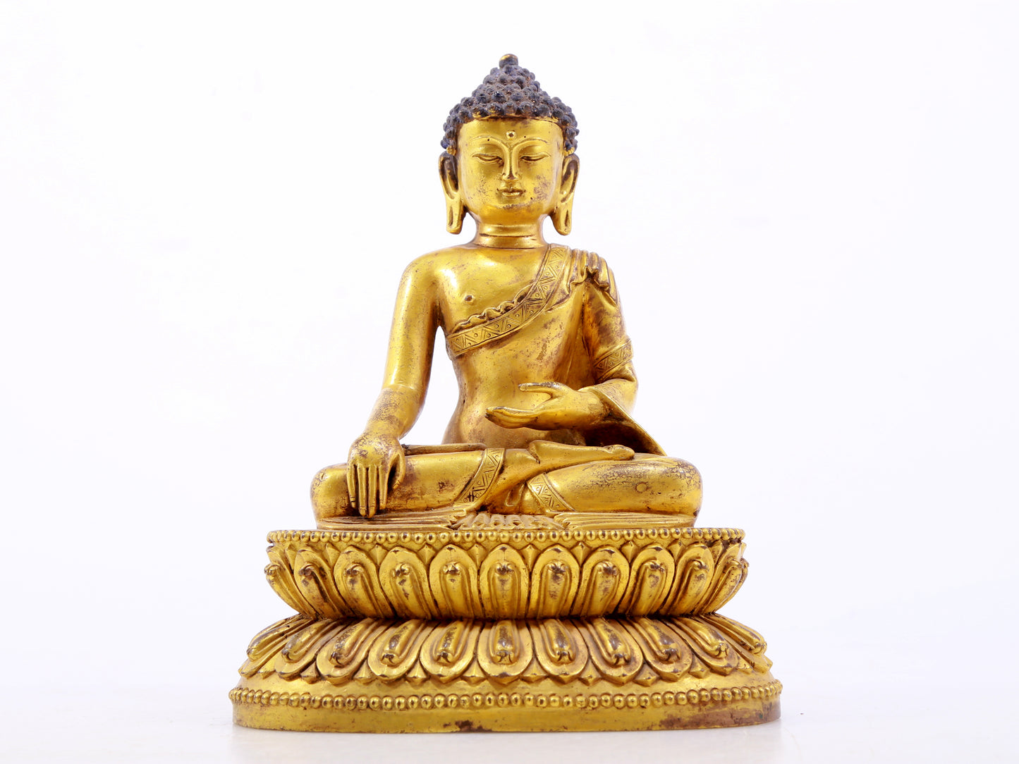 A serene gilt bronze statue of Gautama Buddha