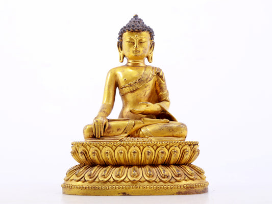 A serene gilt bronze statue of Gautama Buddha