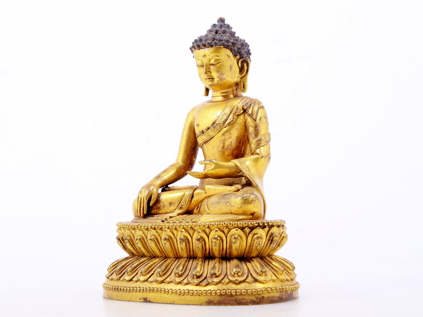 A serene gilt bronze statue of Gautama Buddha