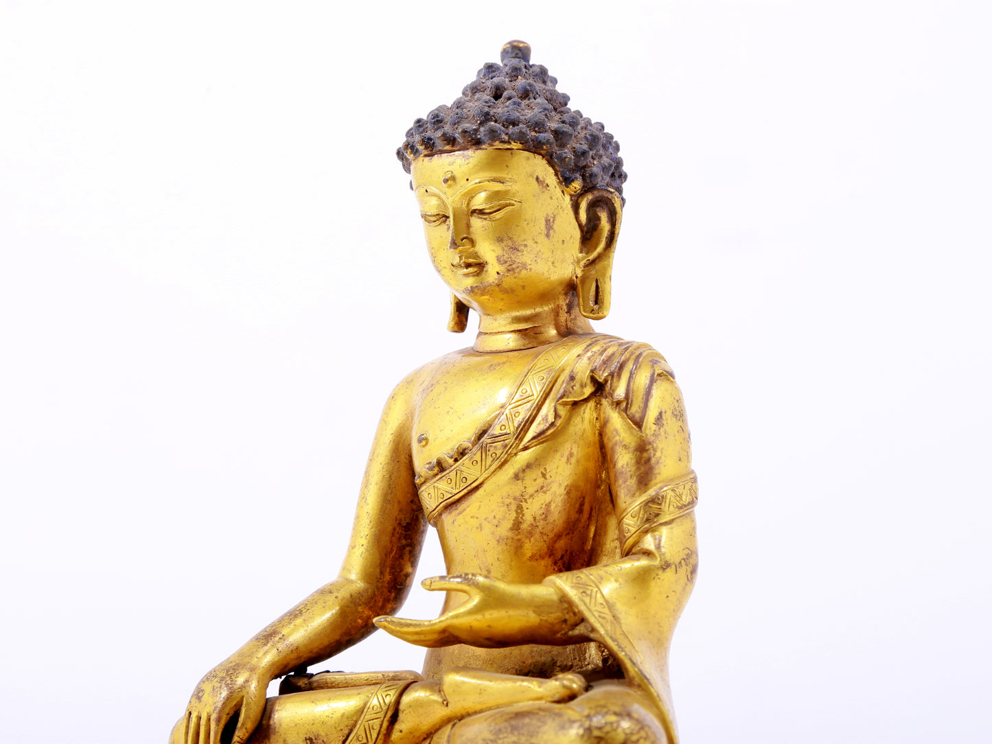 A serene gilt bronze statue of Gautama Buddha