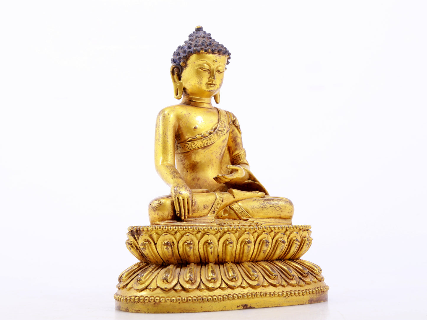 A serene gilt bronze statue of Gautama Buddha