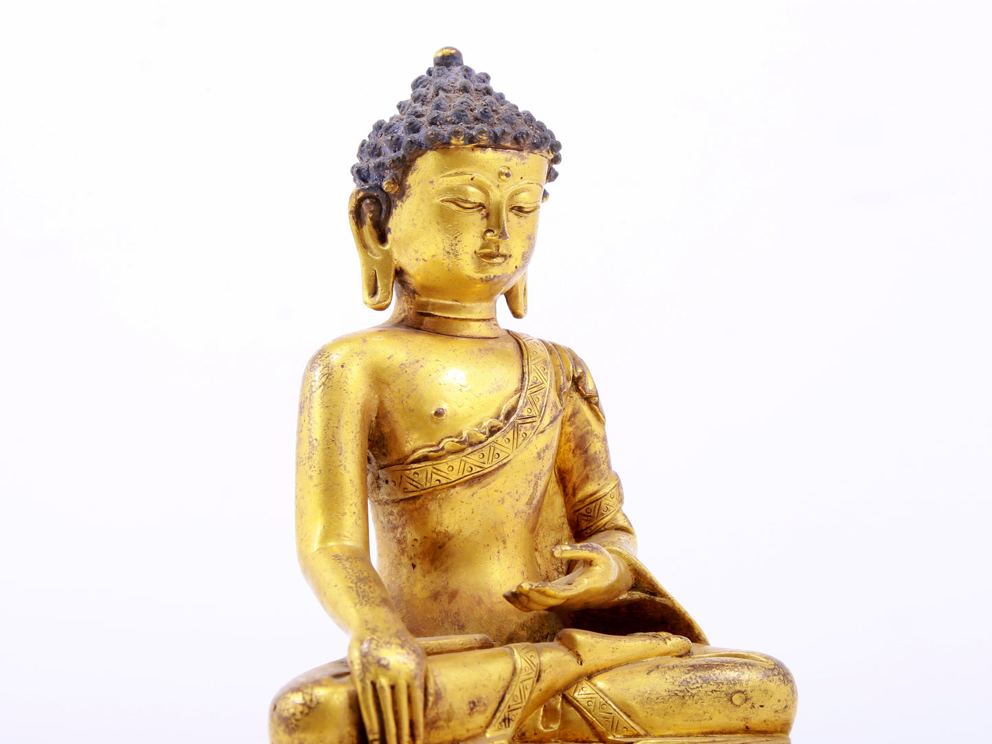 A serene gilt bronze statue of Gautama Buddha