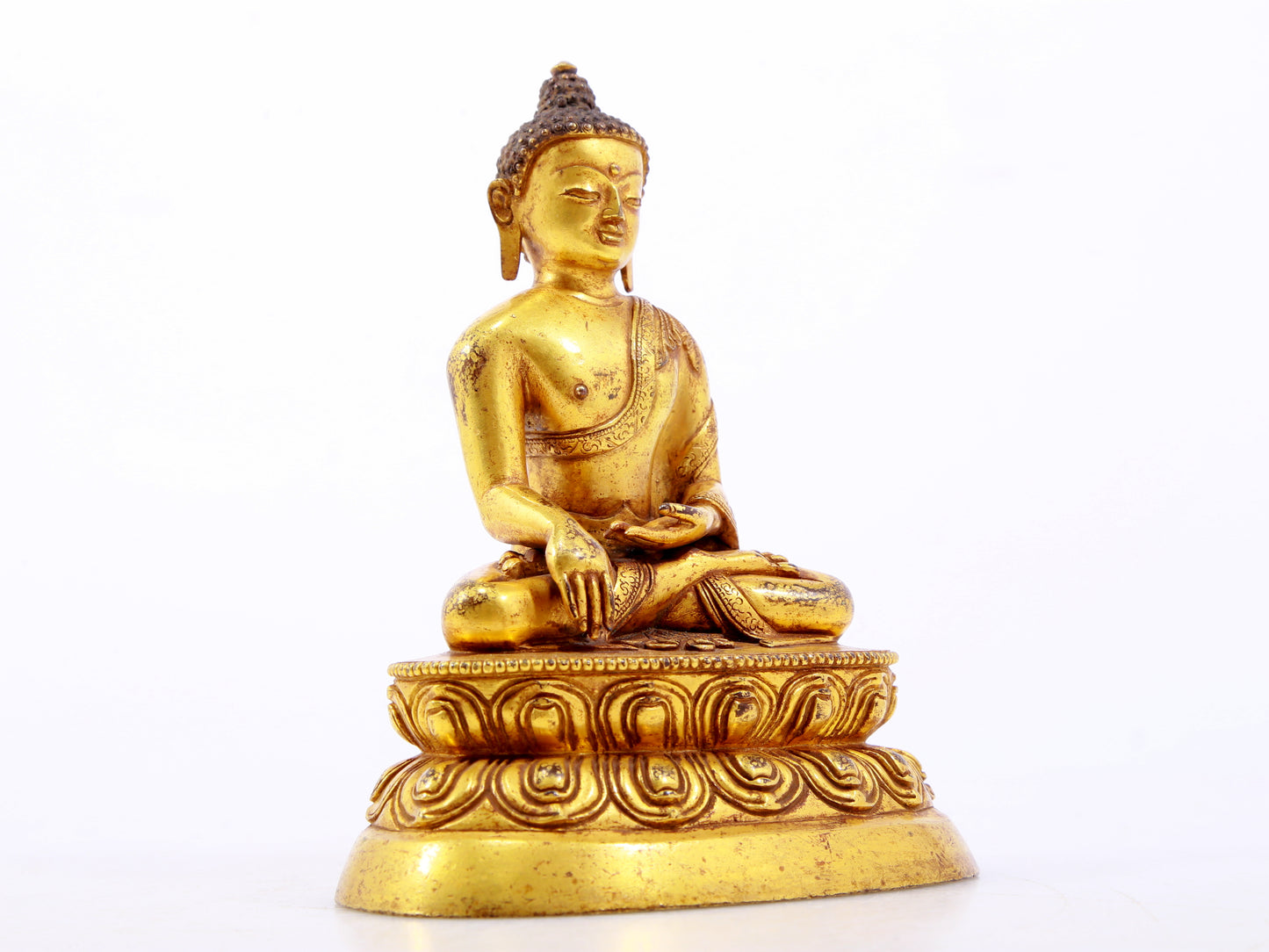 A serene gilt bronze statue of Gautama Buddha