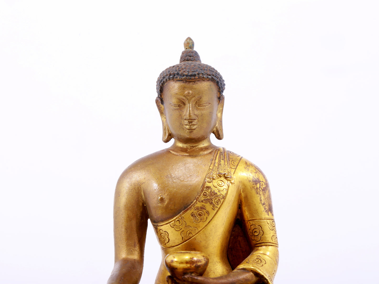 A serene gilt bronze statue of Gautama Buddha