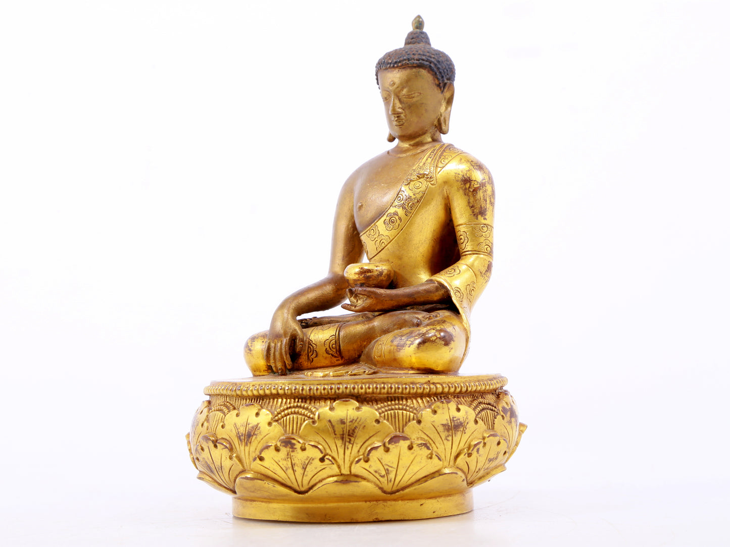 A serene gilt bronze statue of Gautama Buddha