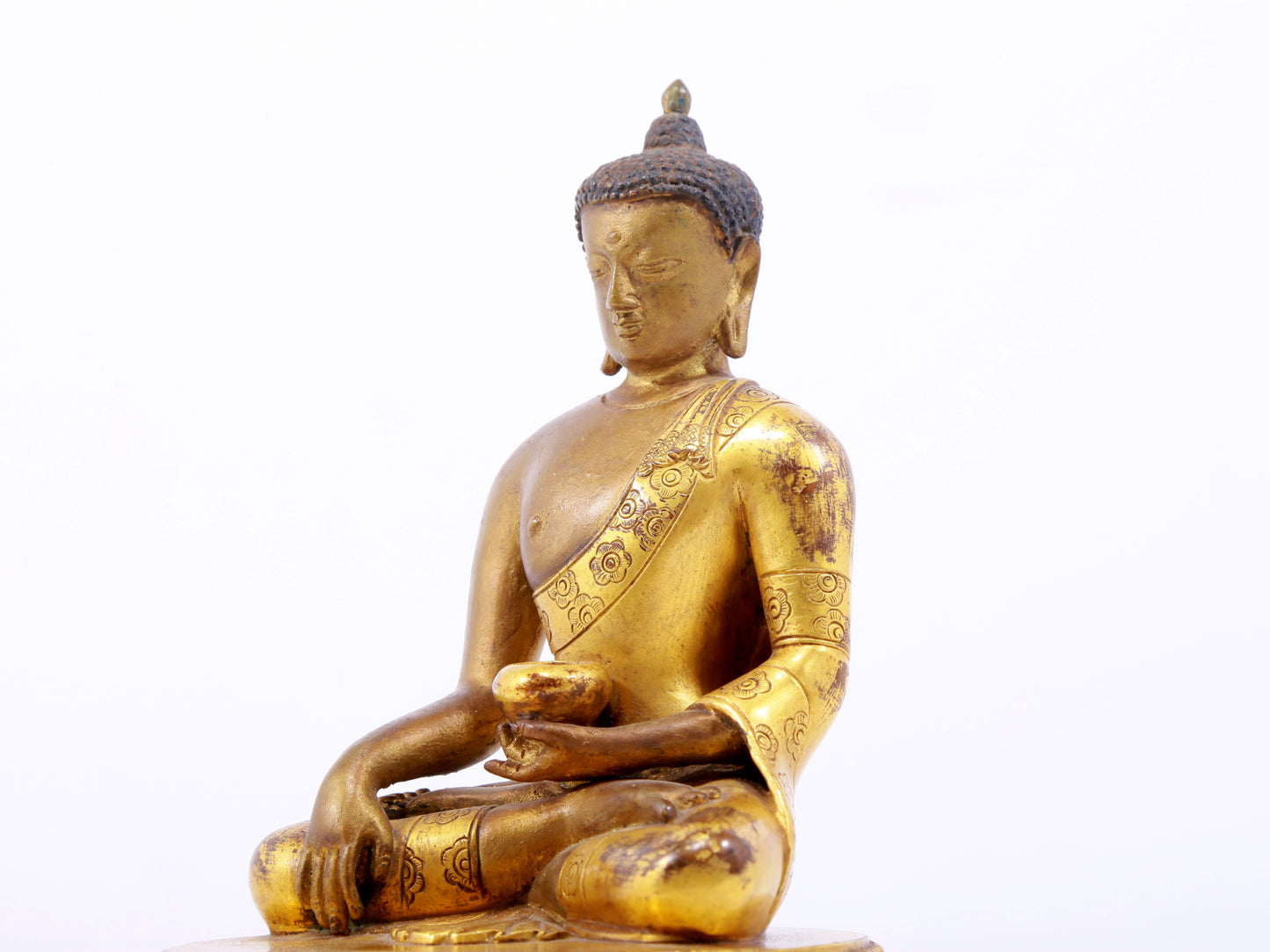 A serene gilt bronze statue of Gautama Buddha