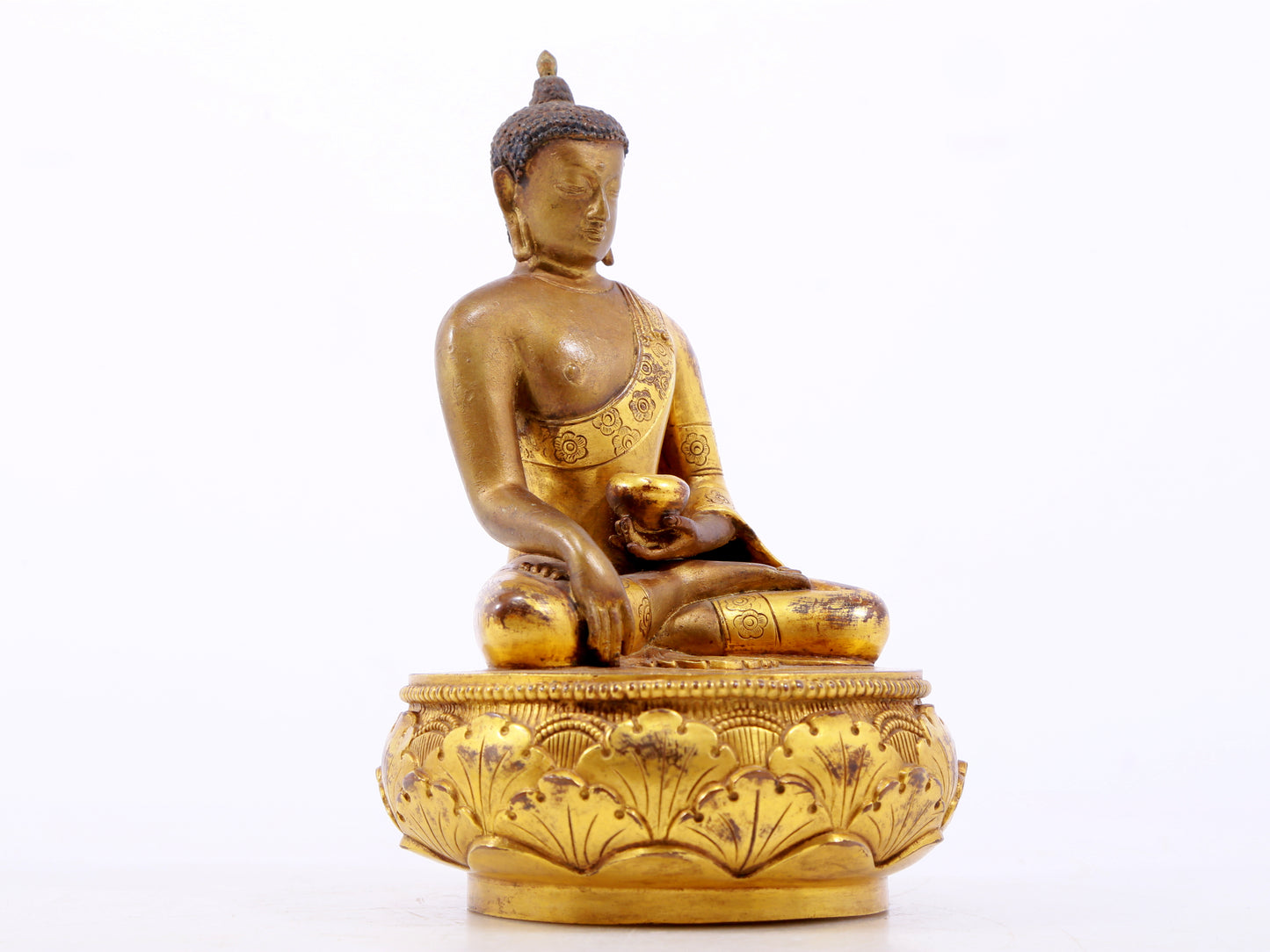 A serene gilt bronze statue of Gautama Buddha