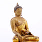 A serene gilt bronze statue of Gautama Buddha