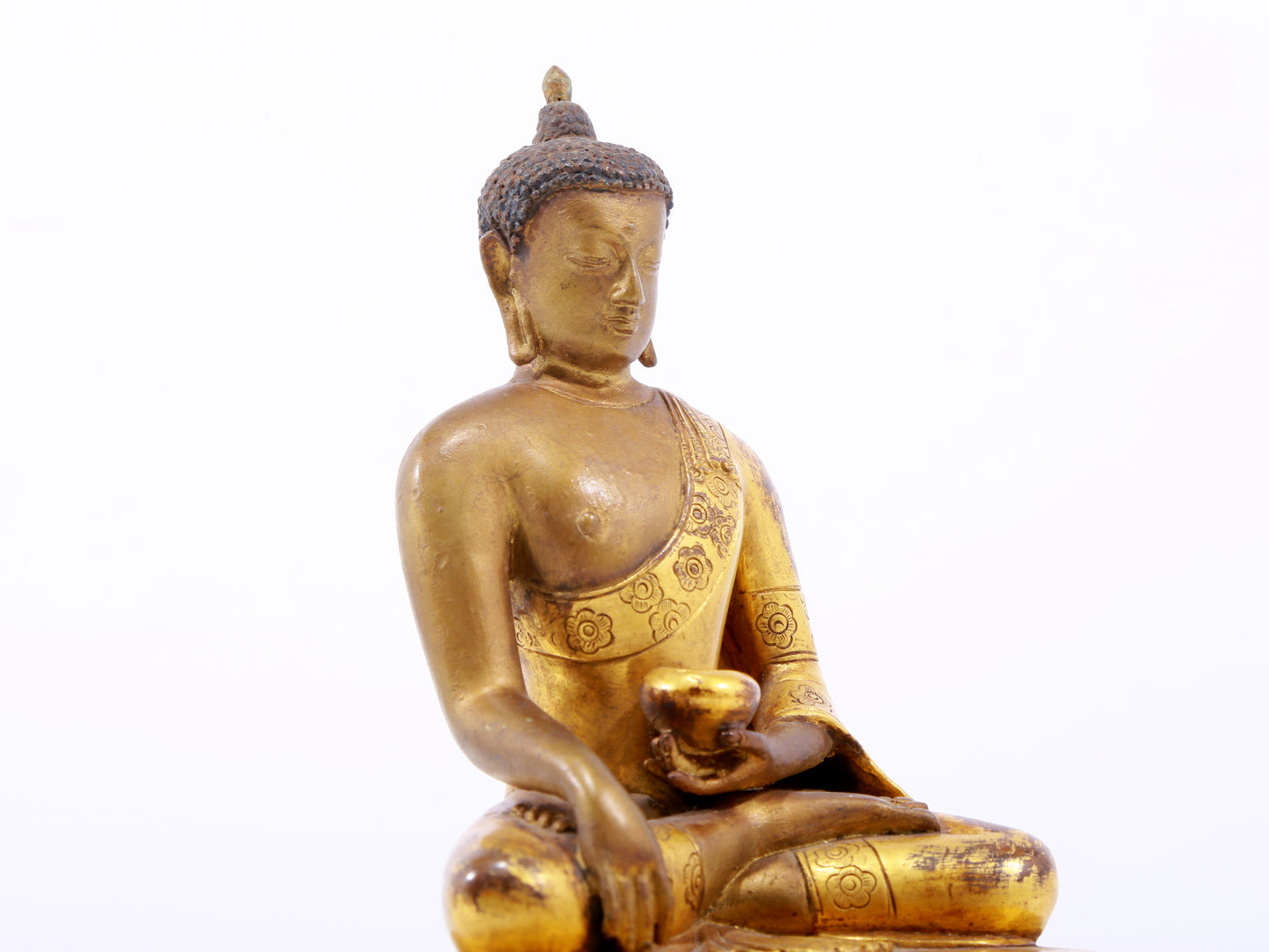 A serene gilt bronze statue of Gautama Buddha