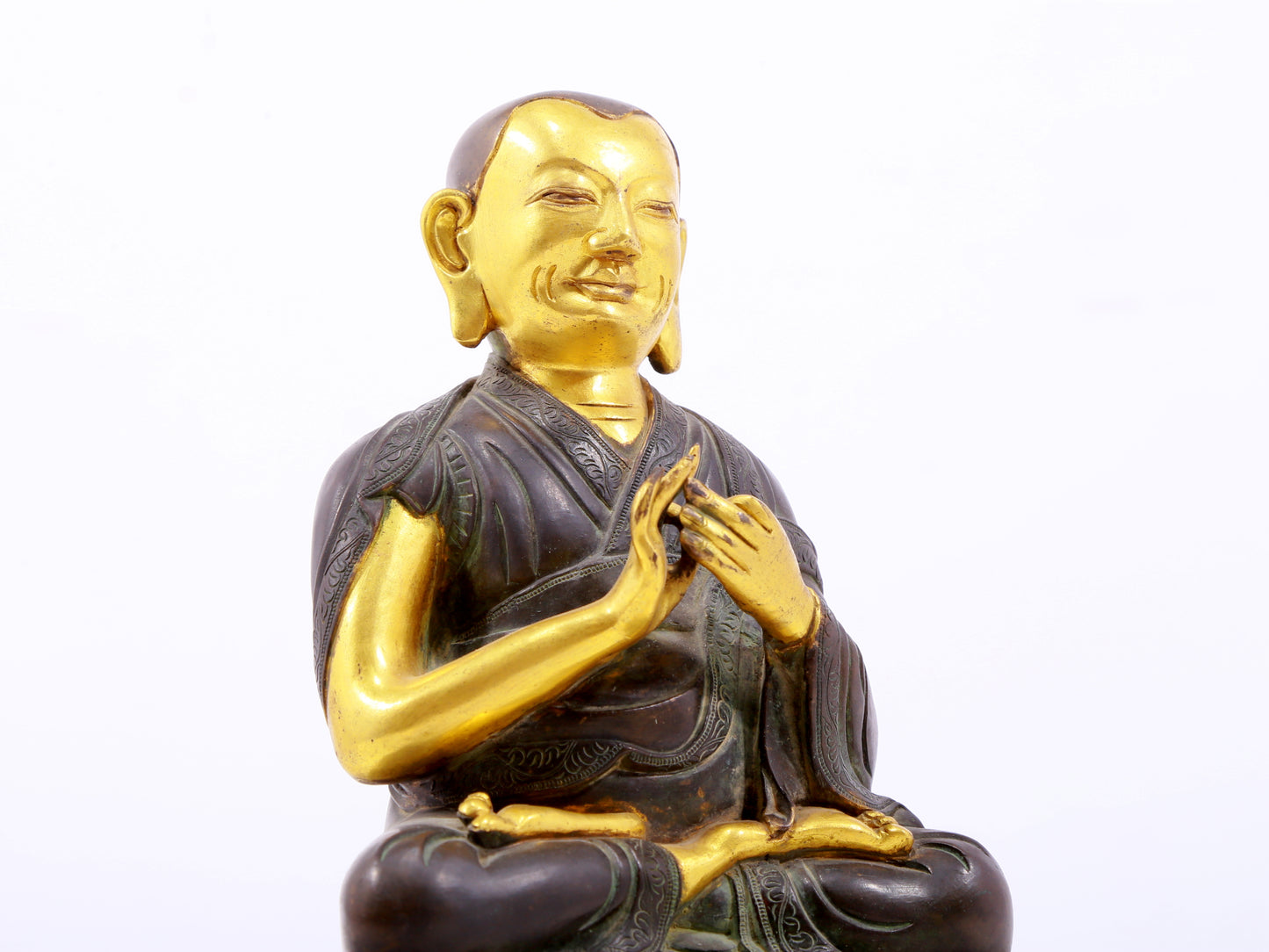 A serene gilt bronze statue of the master