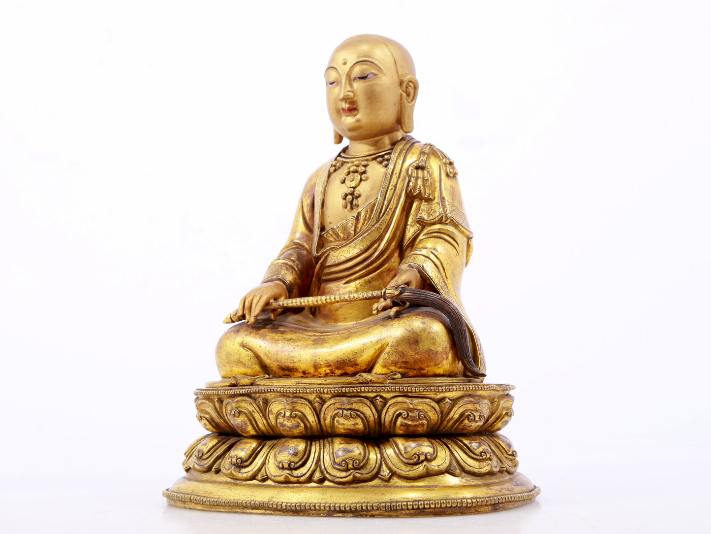 A serene gilt bronze statue of the master