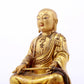 A serene gilt bronze statue of the master