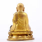 A serene gilt bronze statue of the master