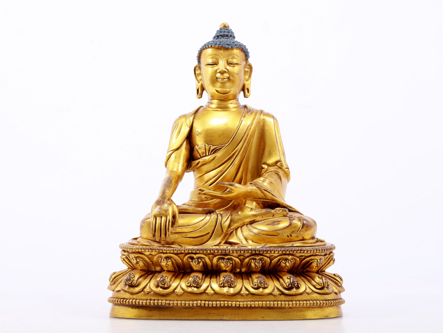 A serene gilt bronze statue of Gautama Buddha