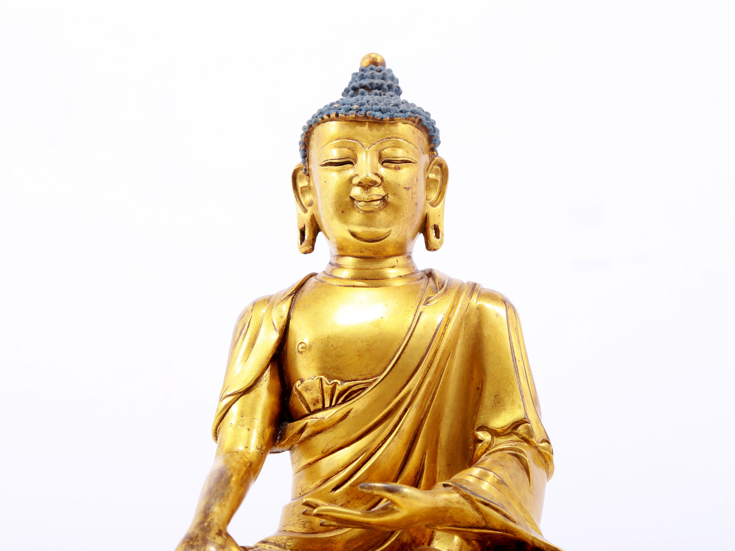 A serene gilt bronze statue of Gautama Buddha