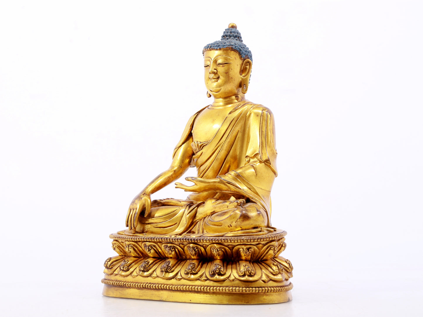 A serene gilt bronze statue of Gautama Buddha