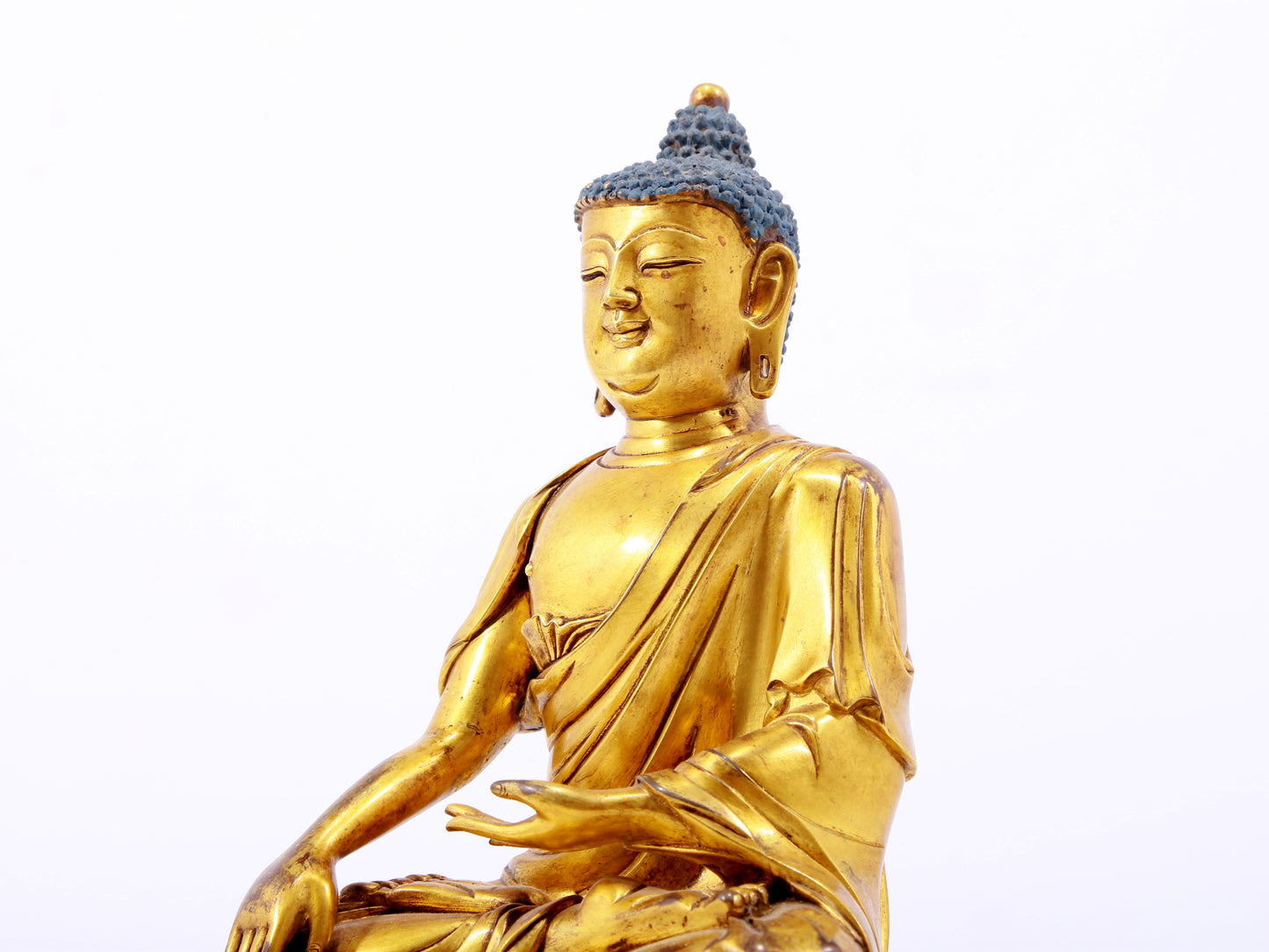 A serene gilt bronze statue of Gautama Buddha