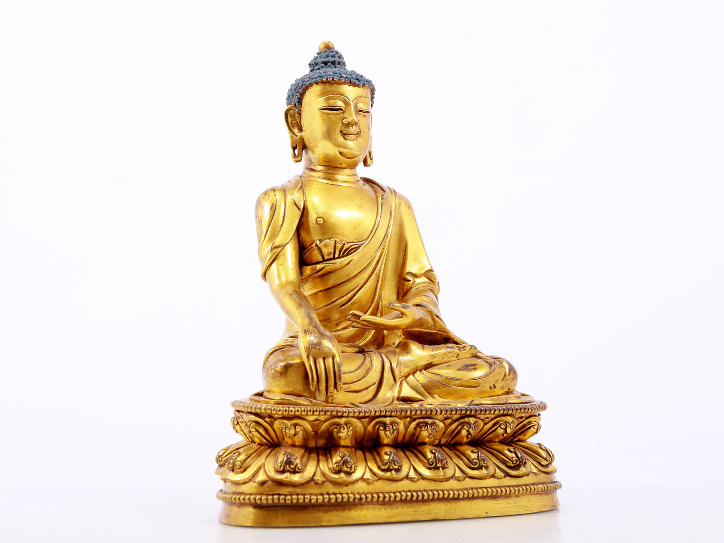 A serene gilt bronze statue of Gautama Buddha