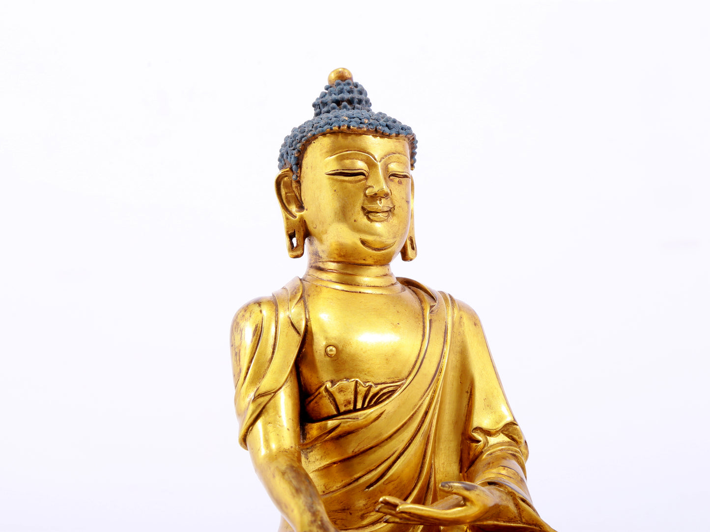 A serene gilt bronze statue of Gautama Buddha