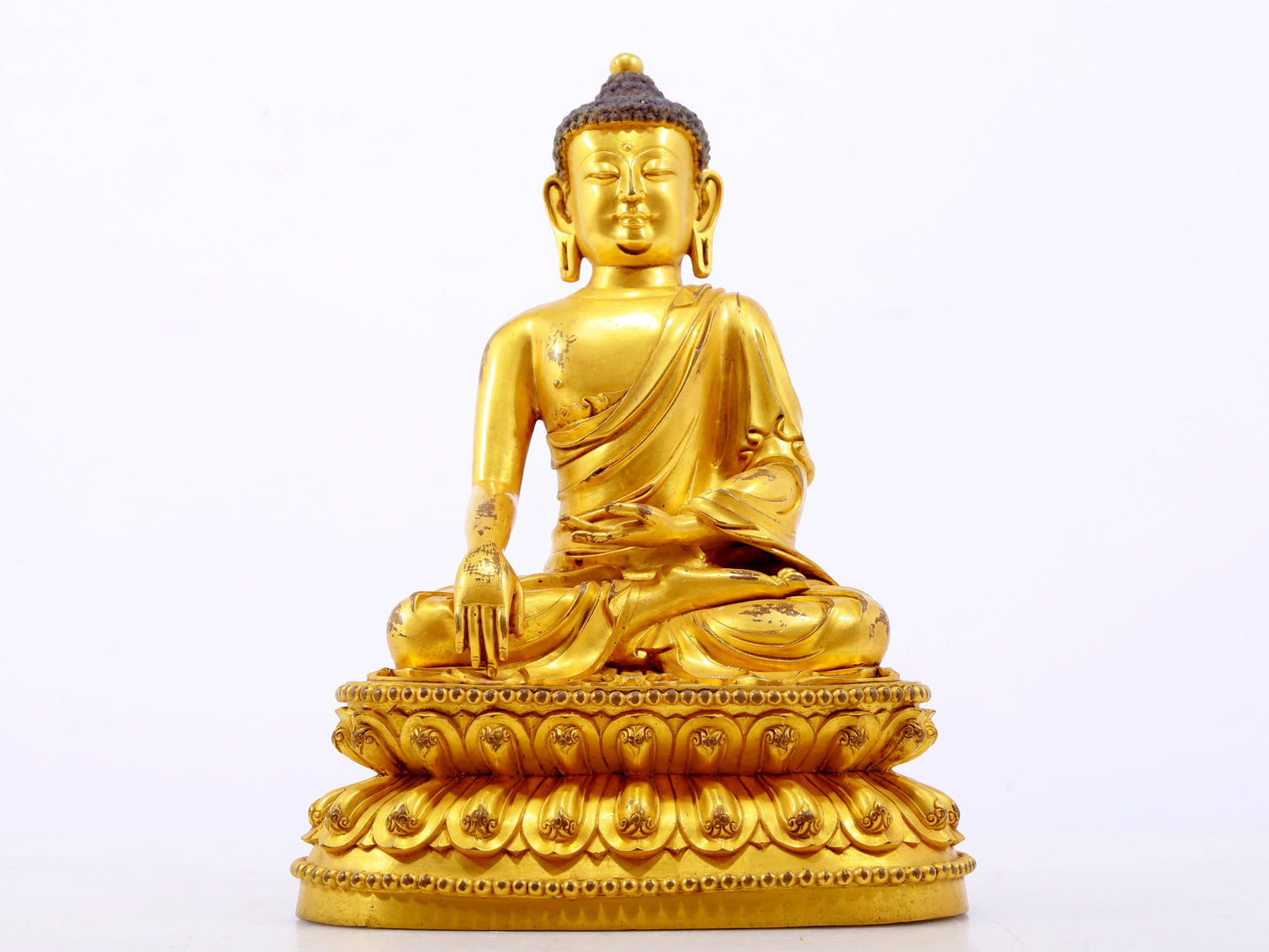 A serene gilt bronze statue of Gautama Buddha