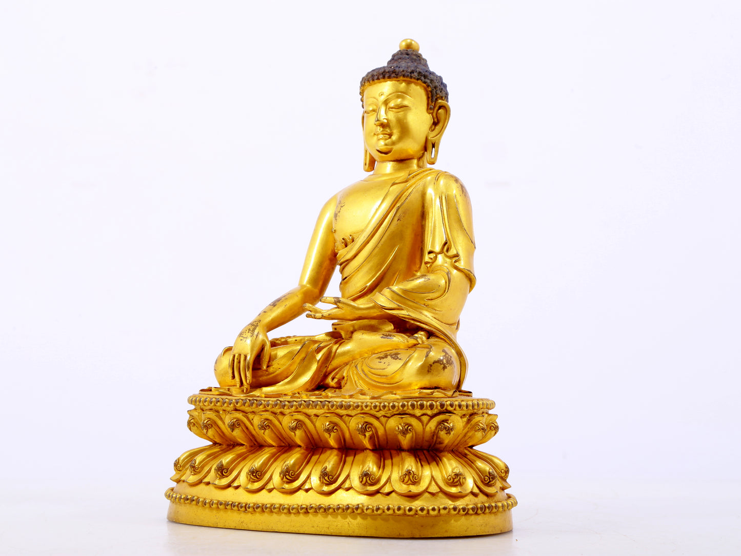 A serene gilt bronze statue of Gautama Buddha