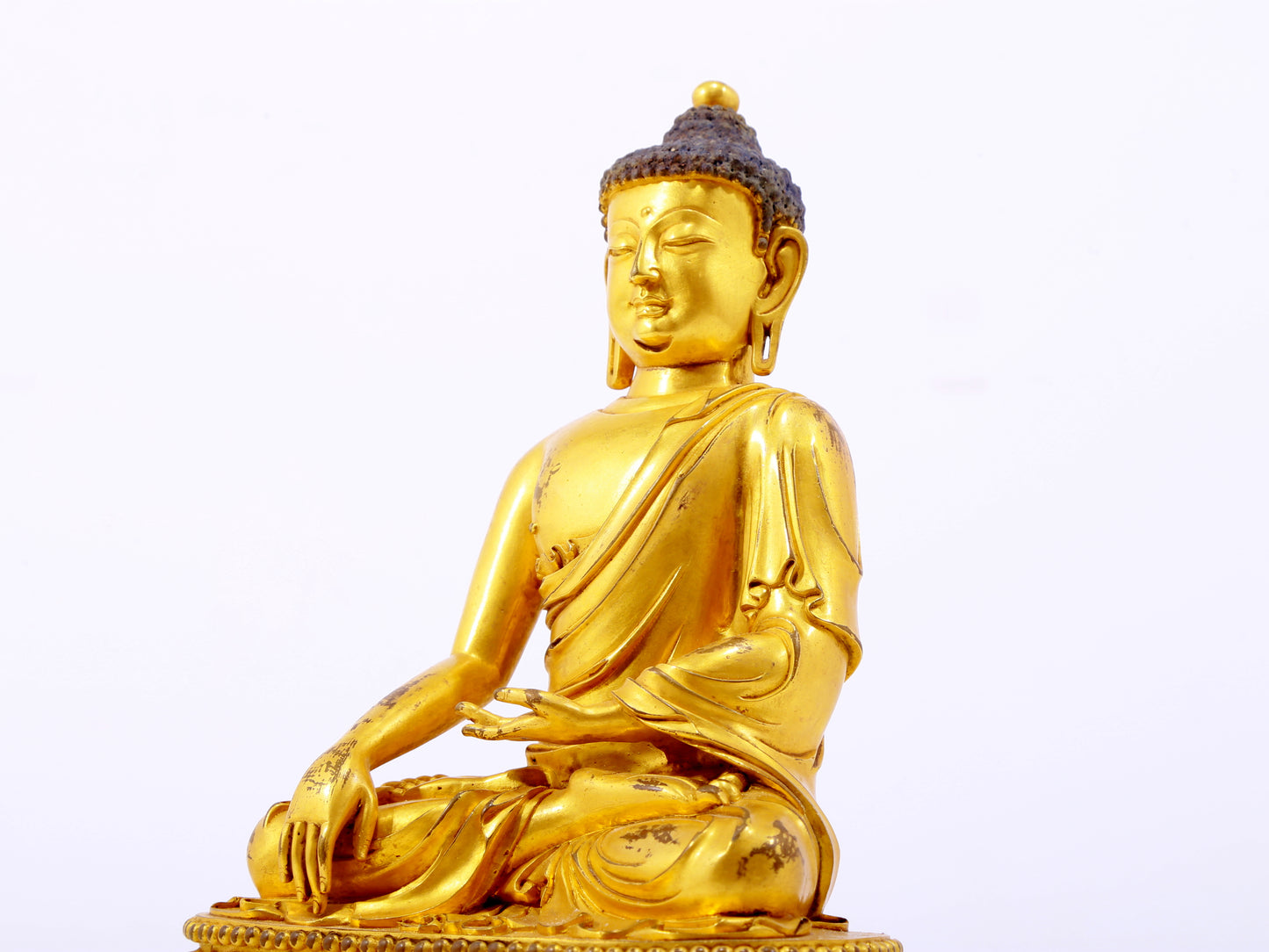 A serene gilt bronze statue of Gautama Buddha