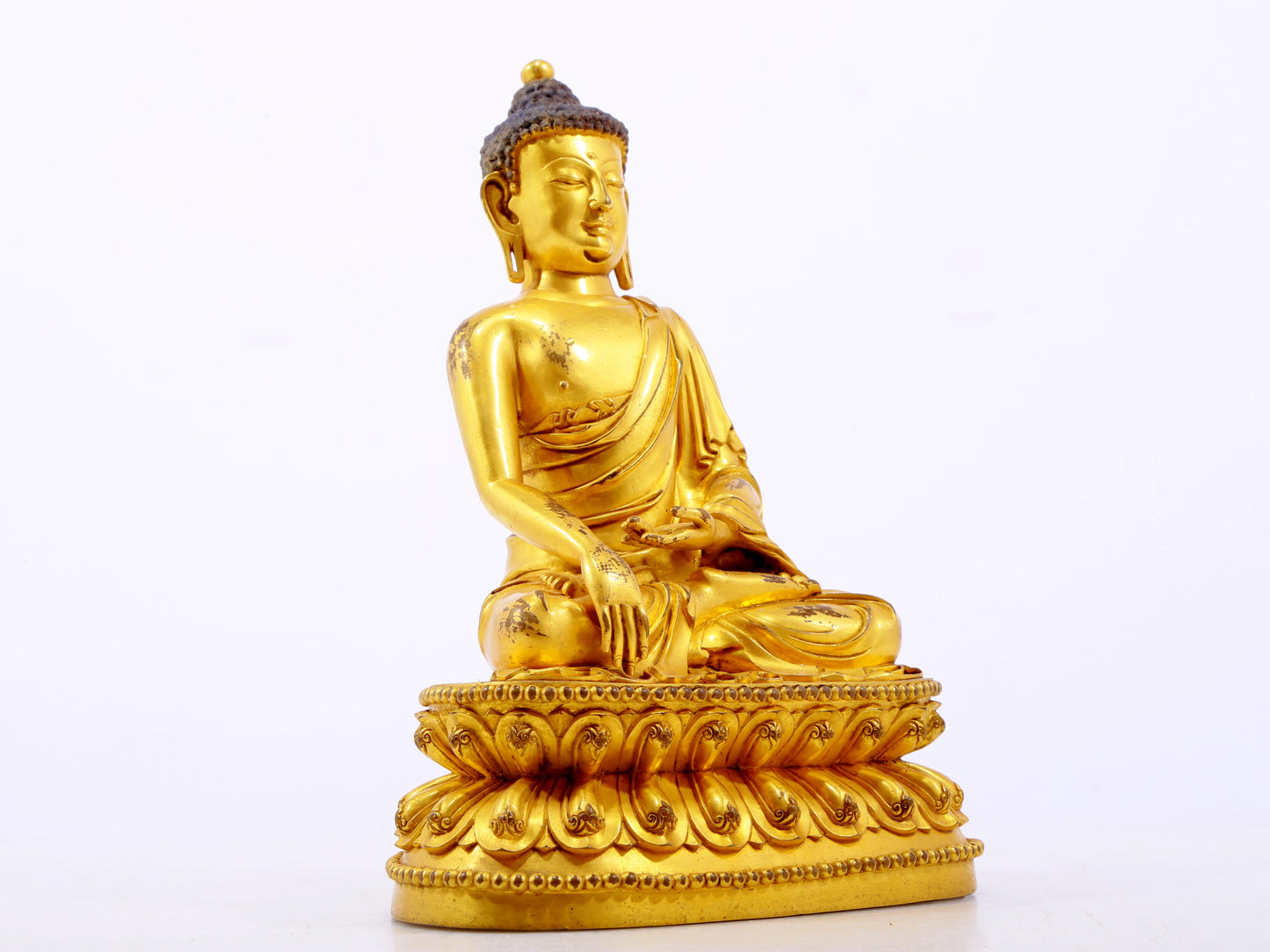 A serene gilt bronze statue of Gautama Buddha