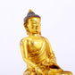 A serene gilt bronze statue of Gautama Buddha