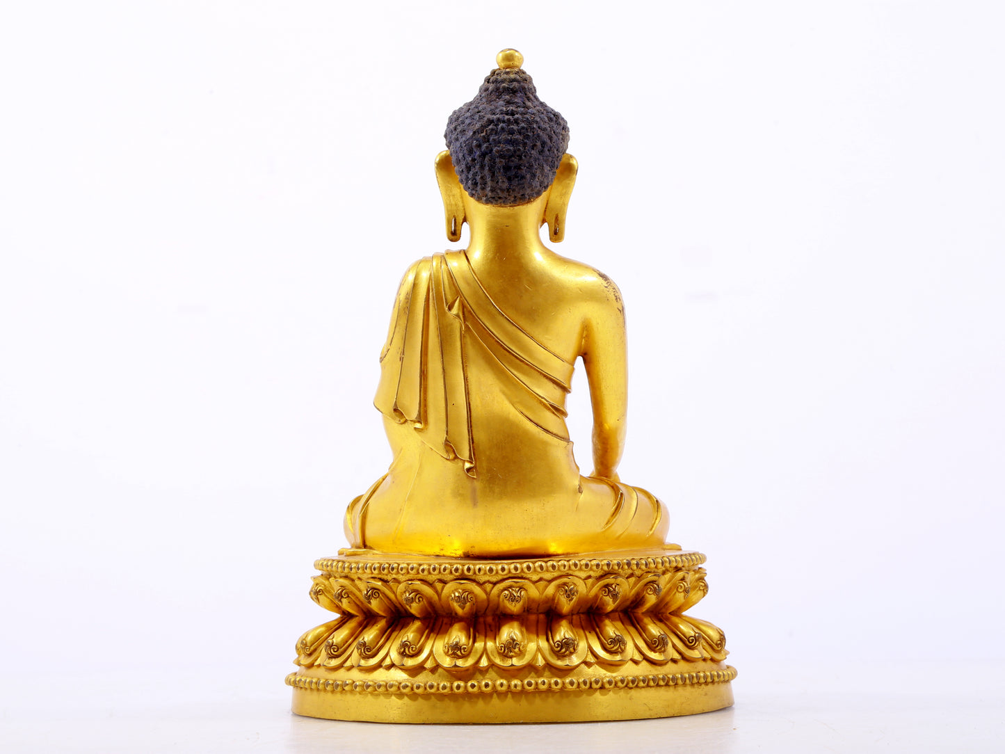 A serene gilt bronze statue of Gautama Buddha