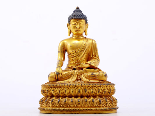 A serene gilt bronze statue of Gautama Buddha