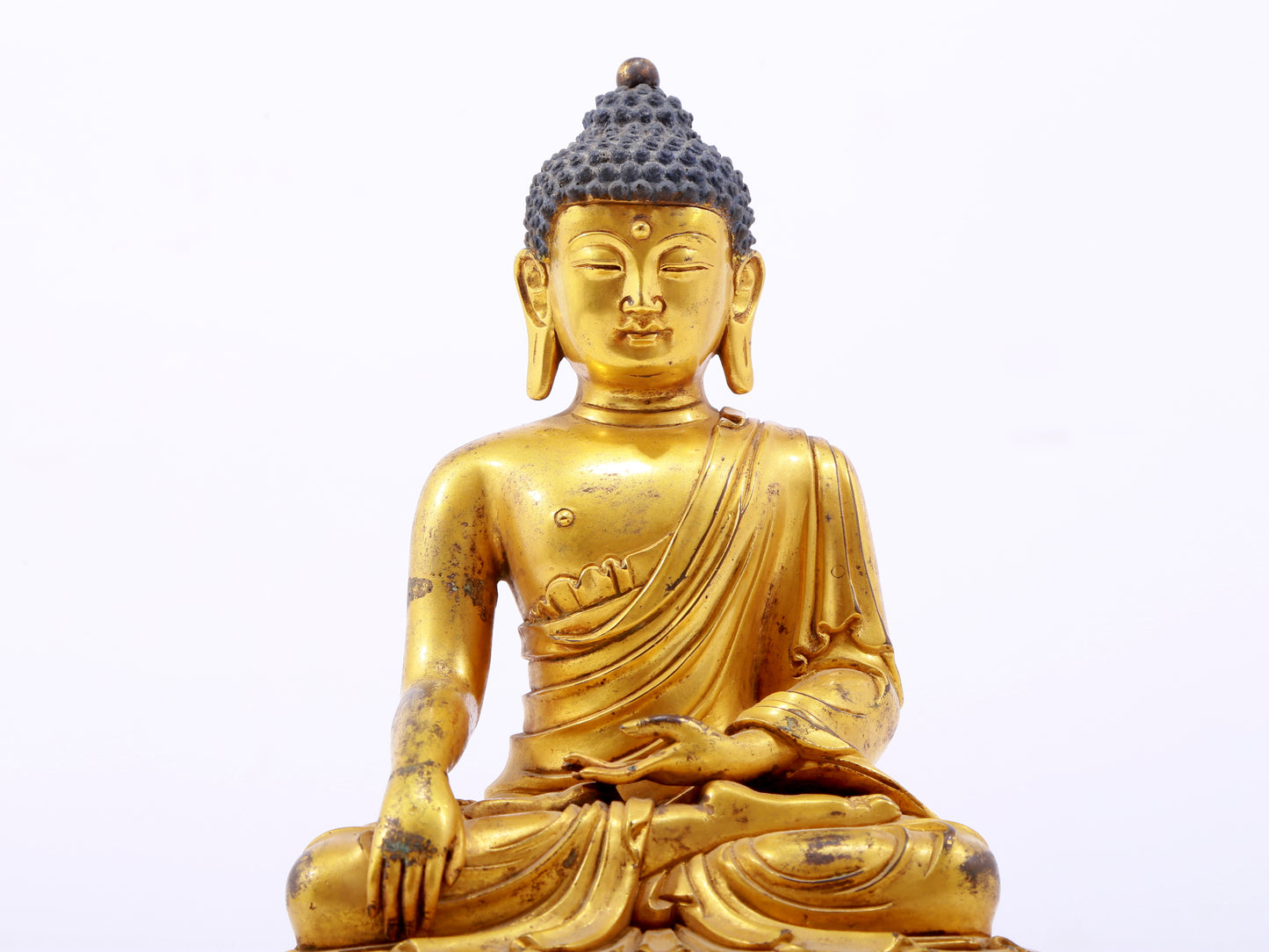 A serene gilt bronze statue of Gautama Buddha