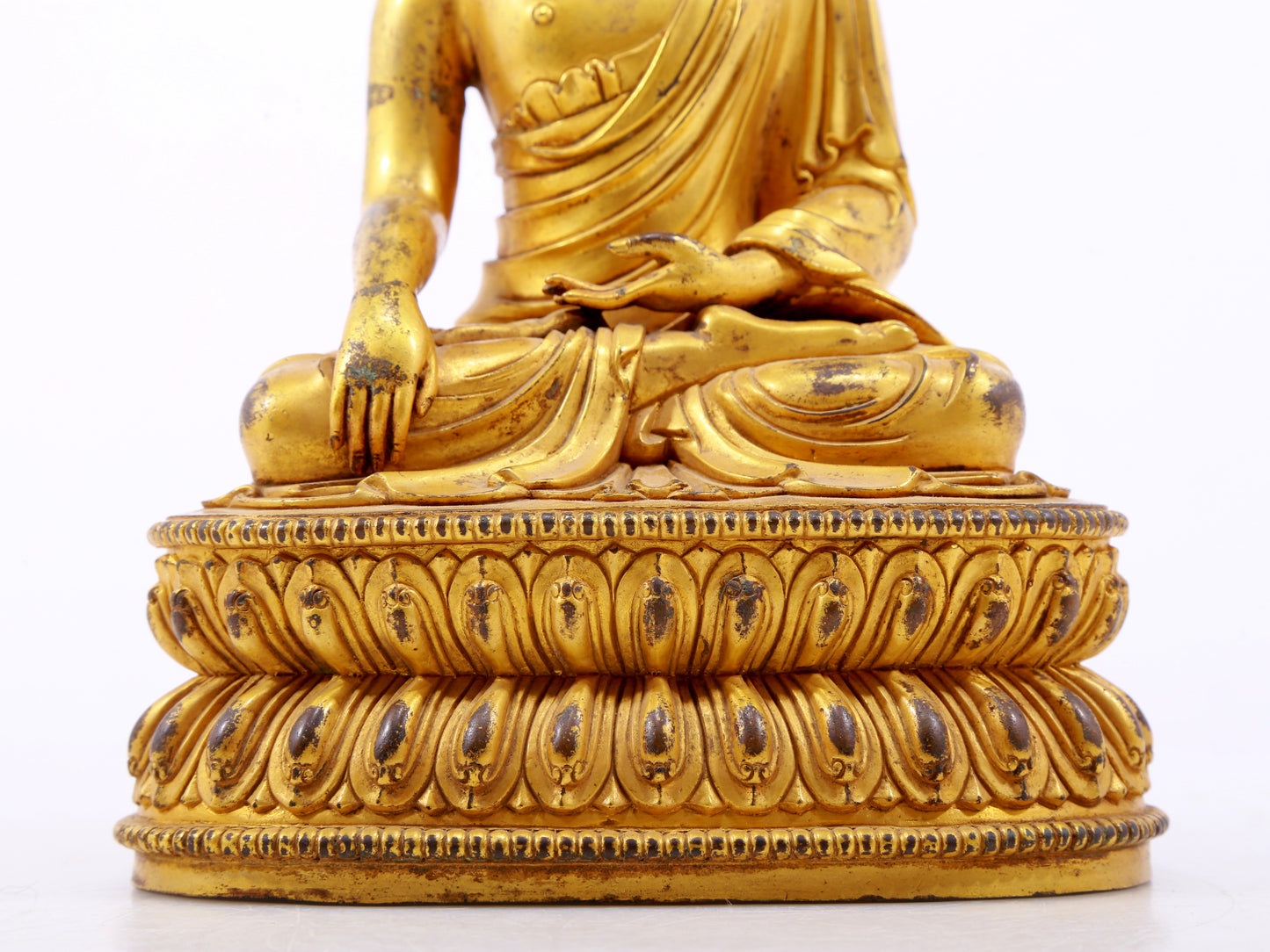 A serene gilt bronze statue of Gautama Buddha