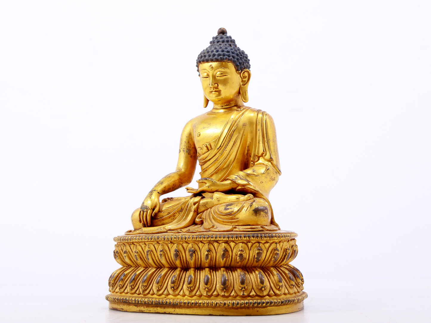 A serene gilt bronze statue of Gautama Buddha