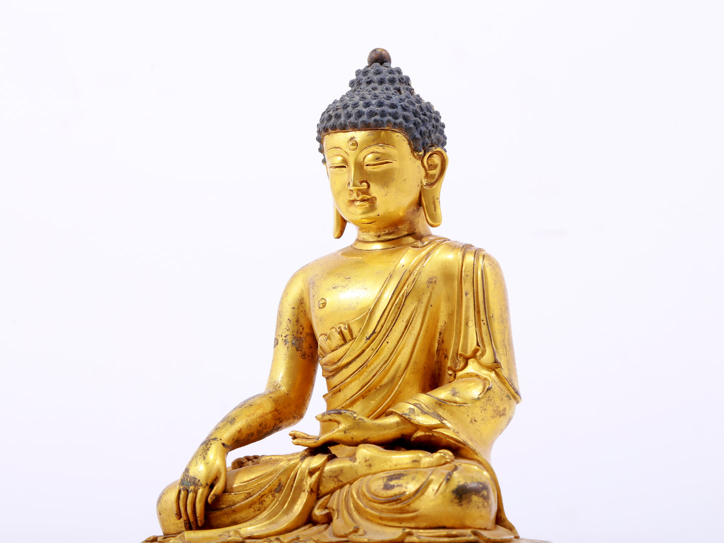 A serene gilt bronze statue of Gautama Buddha