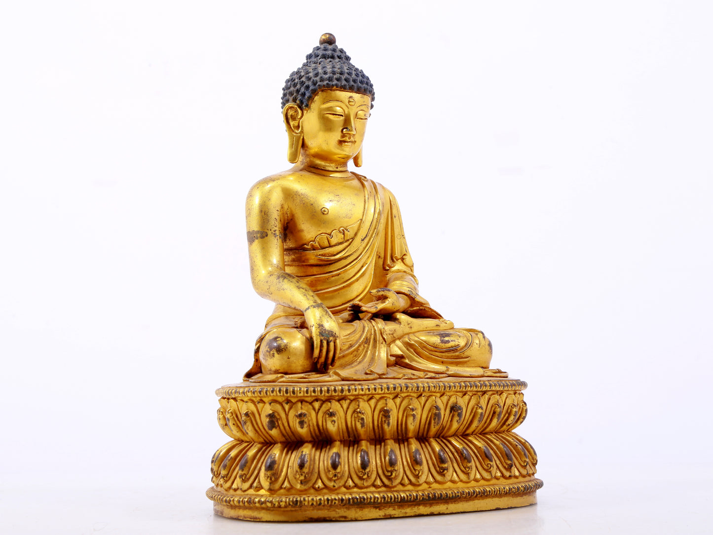 A serene gilt bronze statue of Gautama Buddha