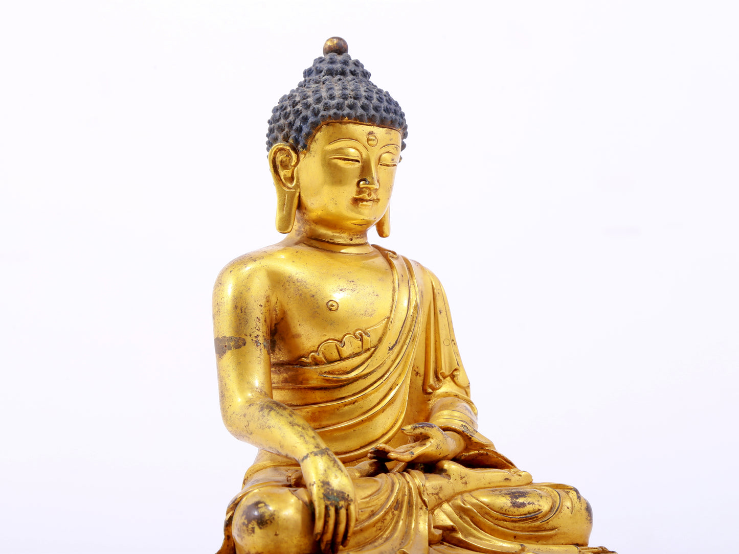 A serene gilt bronze statue of Gautama Buddha