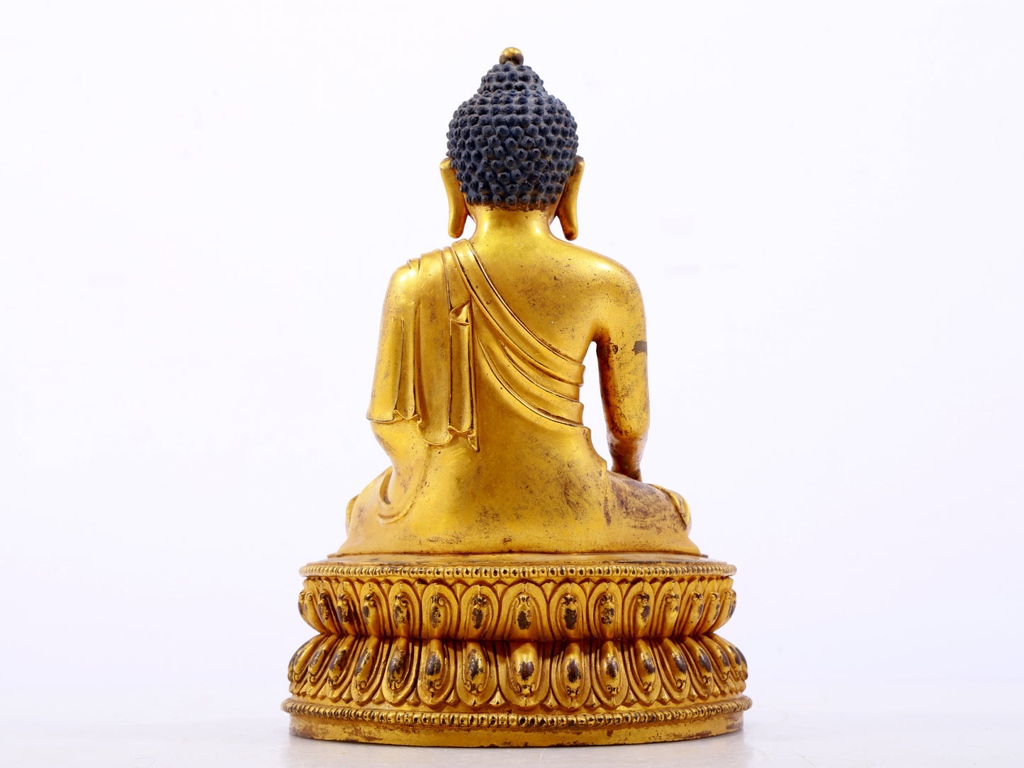 A serene gilt bronze statue of Gautama Buddha